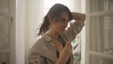 mujer peinando el cabello en casa
