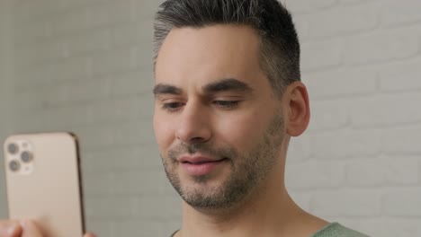 hombre de negocios sonriente teniendo llamada de video en línea en la cámara del teléfono. positivo profesional hablando video chat en el teléfono inteligente en la oficina de casa. hombre de negocios gestando con la mano