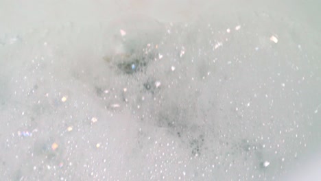 Foam-And-Water-Draining-Down-The-Sink---high-angle,-close-up