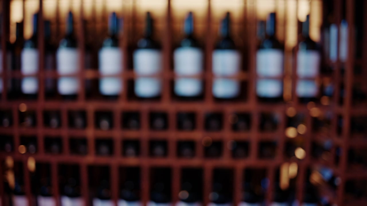 Fileiras de garrafas de vinho armazenadas em uma prateleira de adega de madeira.