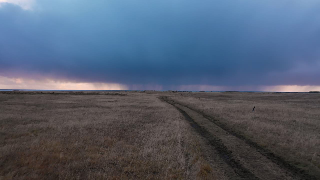Riprese aeree lungo una strada sterrata islandese e campi vicino alla costa.