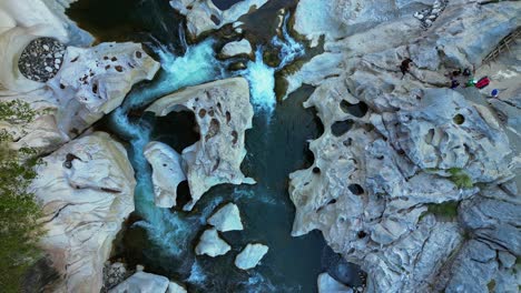 slow shot rotates slightly highlighting water flow around rocks on both sides, emphasizing the natural movement at tinipak river, philippines