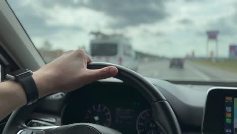 Driver-hand-on-wheel-on-the-interstate