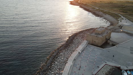 aerial panoramic view of pafos castle against the setting sun, cyprus