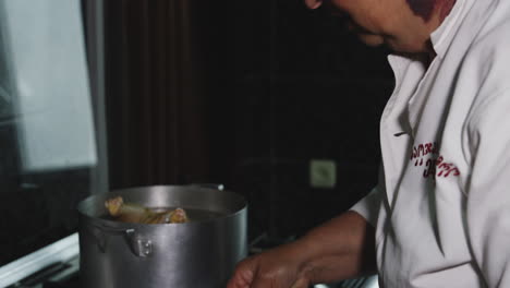 old woman chef with port-wine stain on her neck frying and cooking