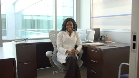 portrait of female doctor working at desk in office