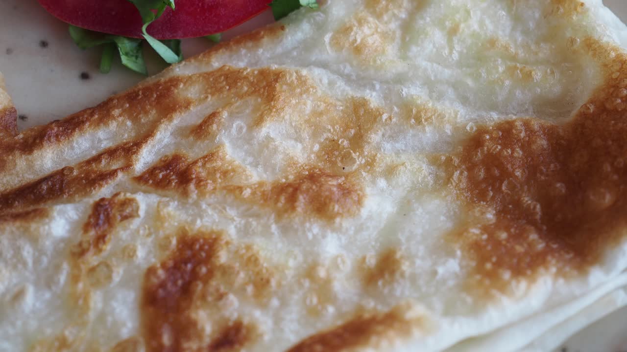 Close-up of a pancake with tomato and greens