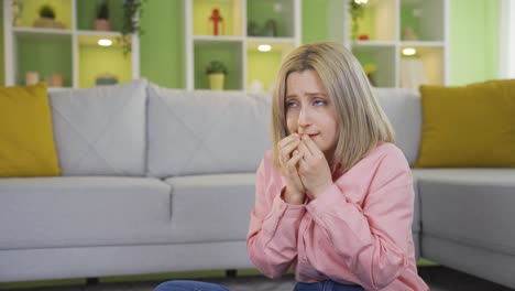 young woman biting nails, stressed from thinking about a problem.