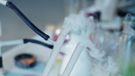 detalles de primer plano de la sustancia de reacción química en ebullición desde el gotero de química frente a la cámara