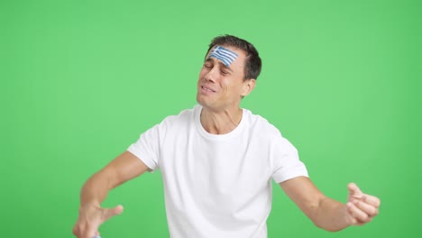 man cheering for greece during a match that is lost