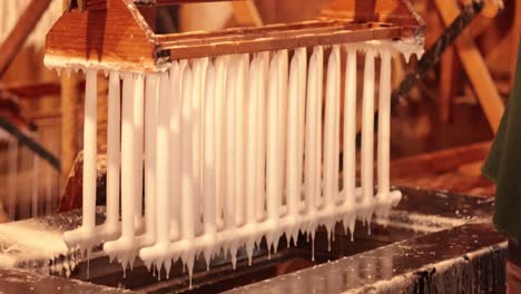 old-fashioned machine creating wax candles efficiently