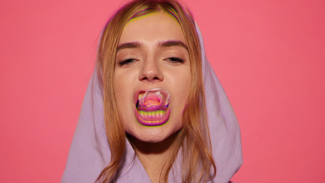 mujer soplando una burbuja de chicle en una sudadera