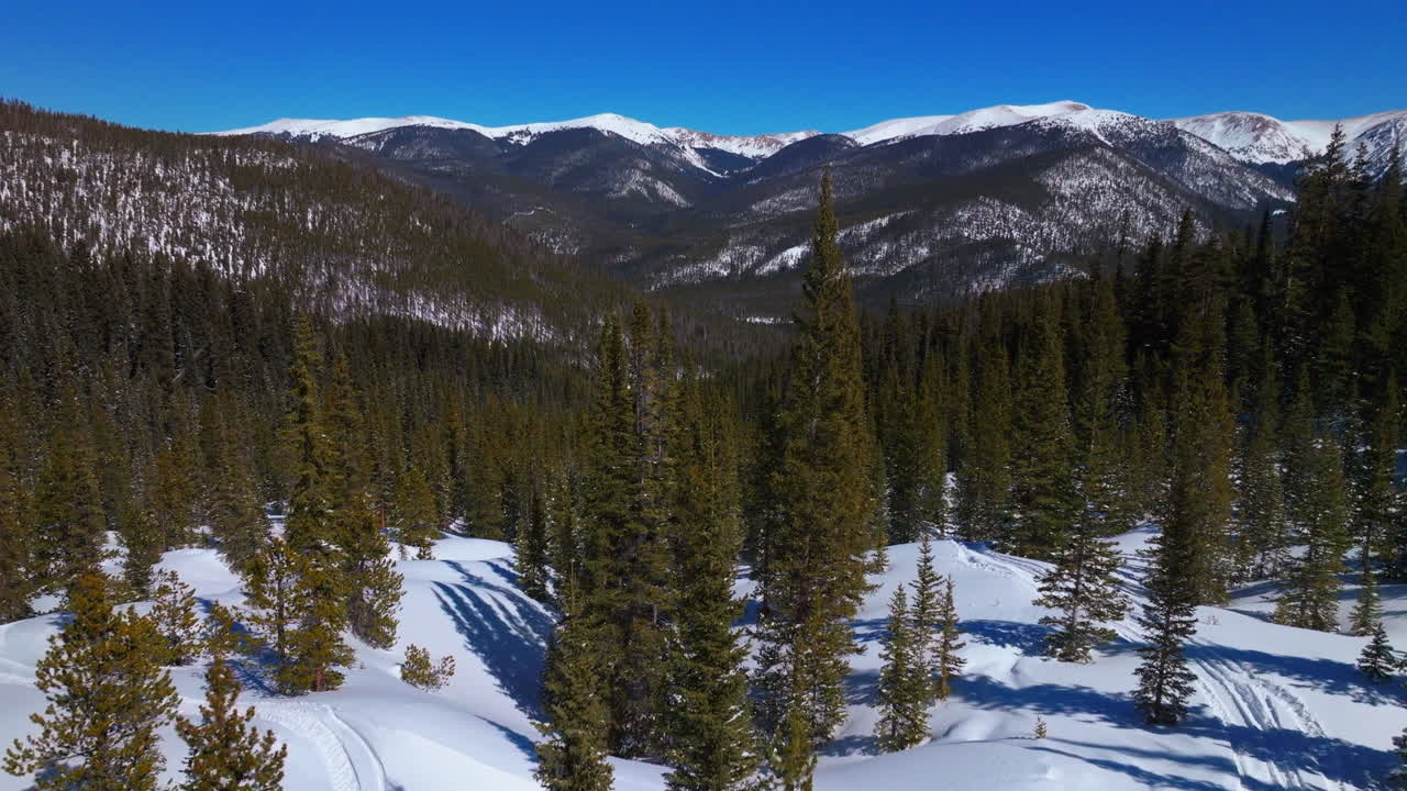 snowmobile trail track boreas mountain pass breckenridge colorado drone aéreo cinematográfico backcountry azul cielo despejado norte bifurcación tigre camino calvo montañas rocosas piedra angular invierno nieve fresca hacia adelante pan up