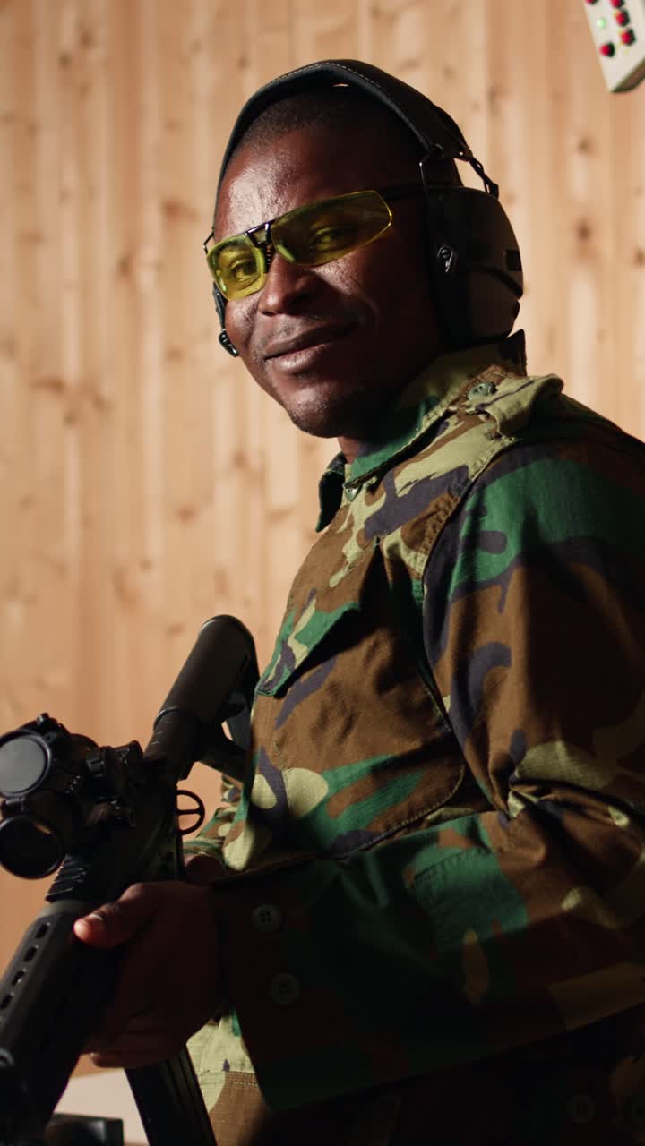 Vertical video Portrait of happy soldier holding rifle, developing marksmanship skills