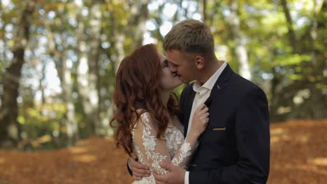 Groom-with-bride-in-the-forest-park.-Wedding-couple.-Making-a-kiss