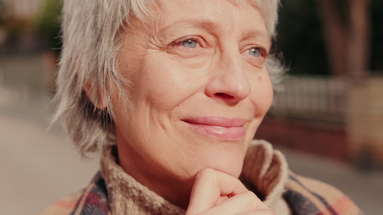 Close-up Portrait of a Thoughtful Senior Woman Smiling Outdoors