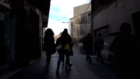 pov following silhouette of people walking through street towards stairs in ordes spain