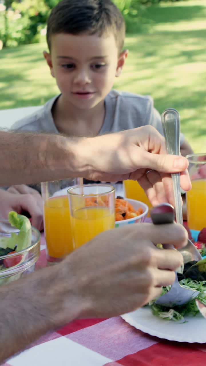 familia feliz está comiendo juntos en el jardín