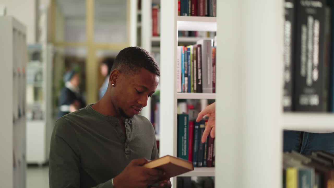 Student receives books in public library. Black man takes folio from librarian visiting university information center. Literature for essay writing