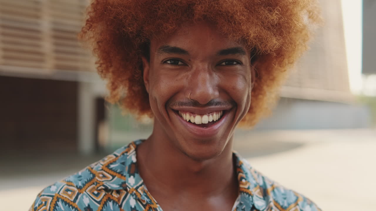 Happy Young Man with Curly Red Hair Smiling at Camera