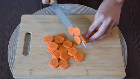 Die-Hand-Der-Frau,-Die-Eine-Carrot.top-ansicht-Schneidet