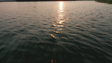 camera dolly in: over disturbed lake water surface