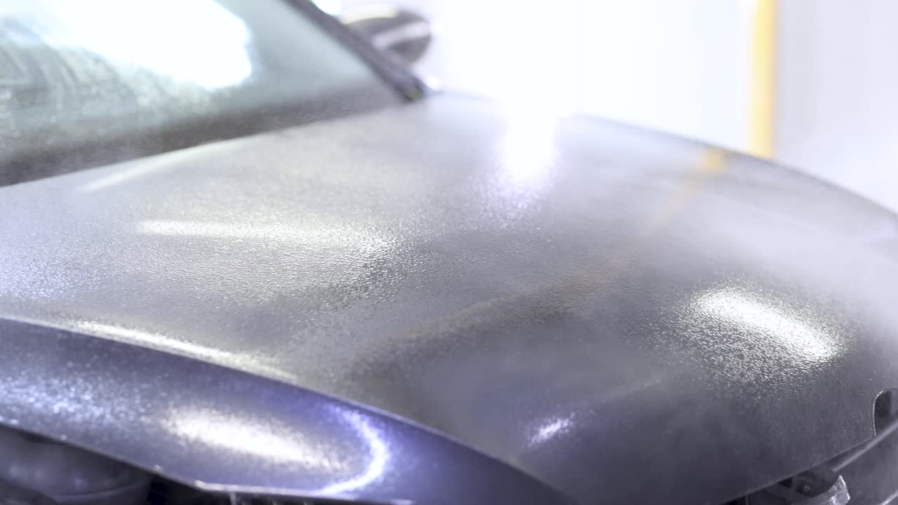 Close-up of a car hood with water droplets