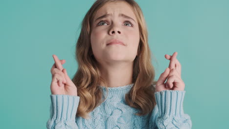 Teenage-Caucasian-girl-with-fingers-crossed-in-front-of-the-camera.