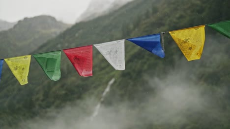 raining on buddhist prayer flags in rain in nepal in the himalyas mountains, close up in rainy season of heavy rain and tibetan prayer flags in the annapurna region trekking in nepal
