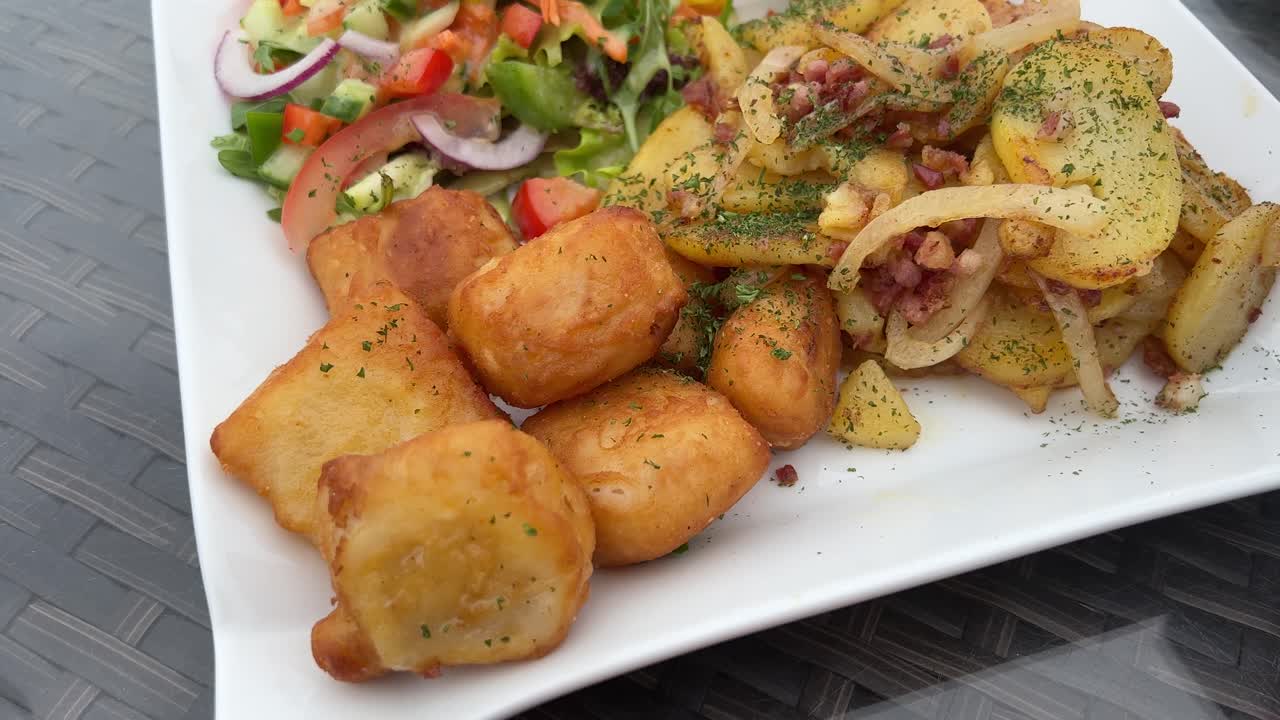 comer pescado frito con patatas, ensalada y salsa