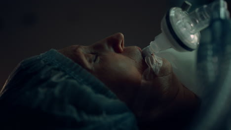 patient surgical oxygen tube lying in dark sterile operating room portrait.