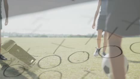 Animation-of-whistle-and-game-plan-over-happy-diverse-schoolboys-playing-football