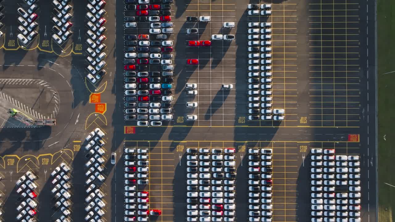 Aerial top down of car manufacturer parking lot with finished vehicles
