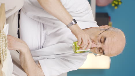 Vertical-video-of-The-old-man-who-drinks-water-at-regular-intervals.-The-old-man-seeks-healing.