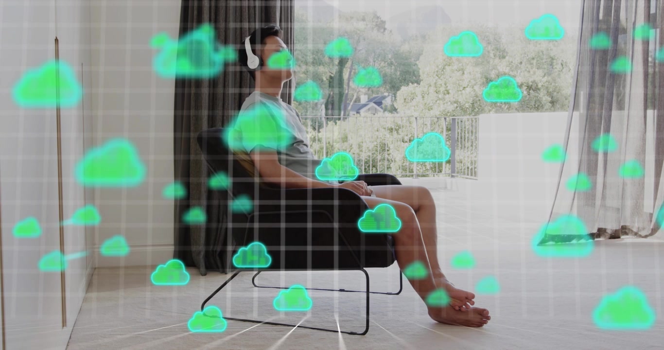 Asian male shifting placing headphones starting green cloud icons streaming over grid in tech demo