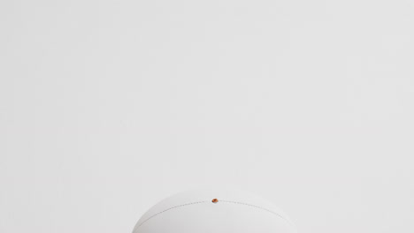 white rugby ball on white background with copy space, slow motion