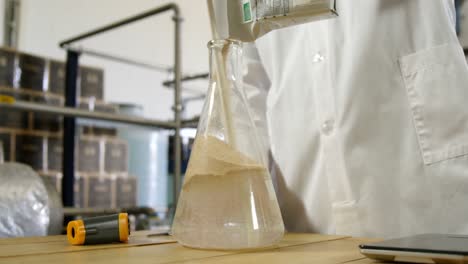 male worker pouring liquor in flask 4k