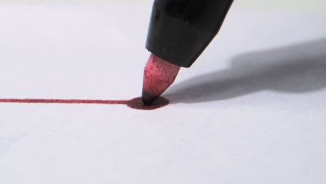 marcador rojo dibujó la línea y la tinta esparcida en el papel de primer plano