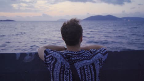 the man looking out to sea from inside the ship.