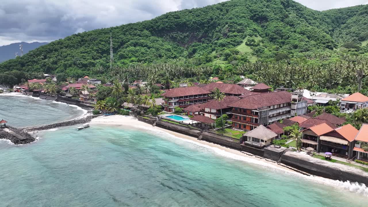 Aerial of hotels on beachfront, vacation in Bali, tropical destination. Aerial panoramic, Candidasa Beach.