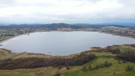 Aerial:-Flying-Over-Calm-Lake,-Forest-And-Mountains-In-Poland