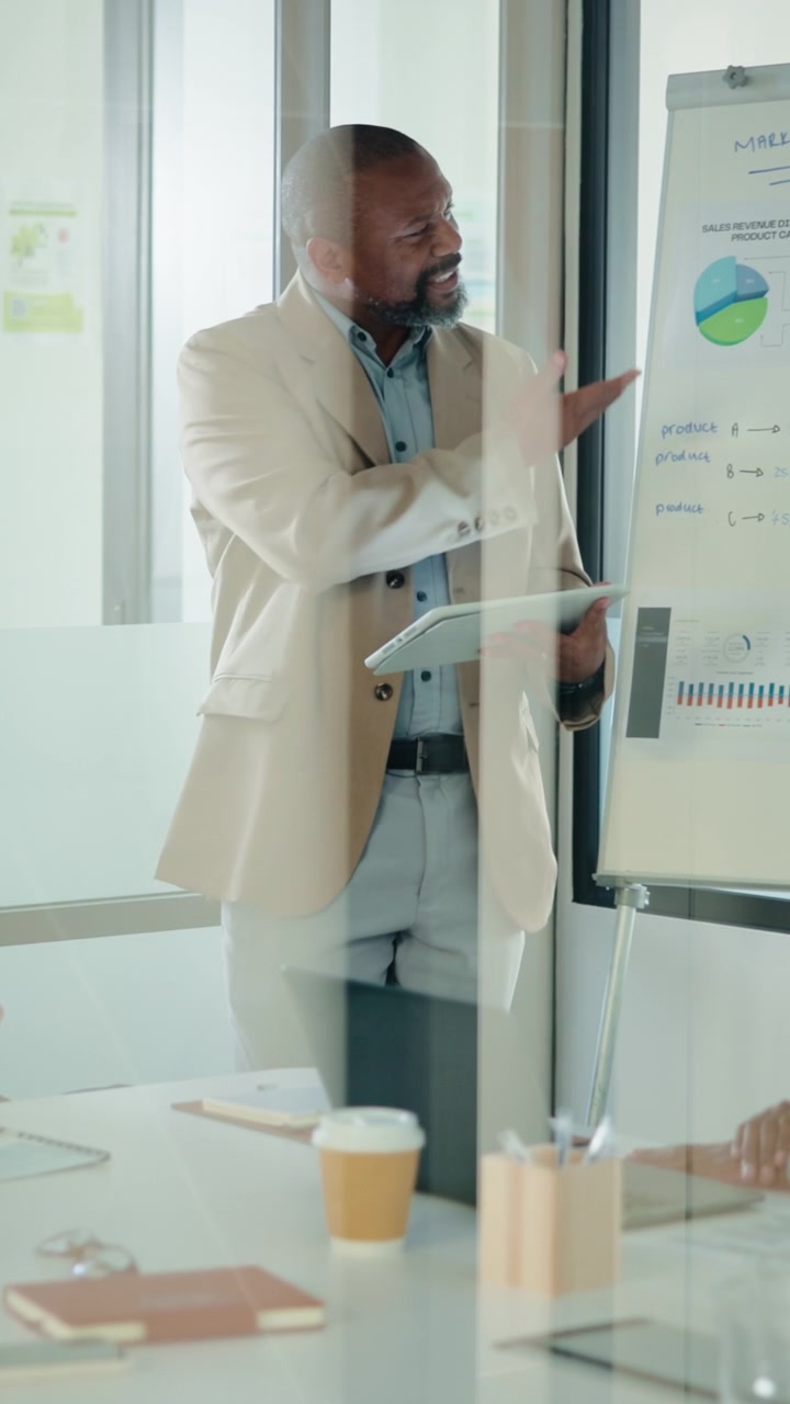 Professional Businessman Presenting Data to Colleagues in Office Meeting