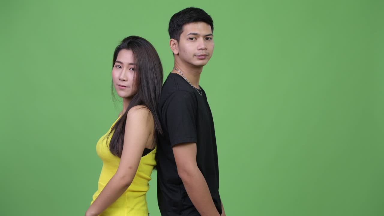 Young happy Asian couple back to back