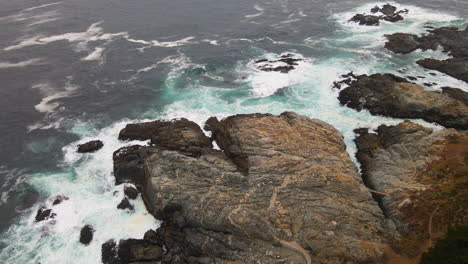 AERIAL---Rocky-shore-in-Zapallar,-Valparaiso,-Chile,-wide-spinning-shot