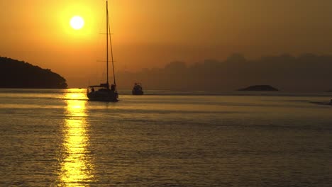 sunset at vela luka, croatia, with a sailboats and motorboats traveling across the view