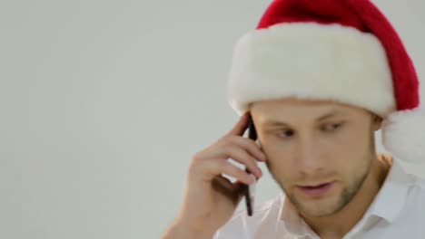 man in santa hat talking on phone