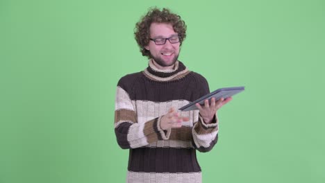 un joven guapo con barba y cabello rizado.