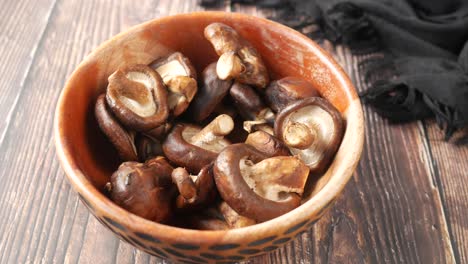 dried shiitake mushrooms in a wooden bowl