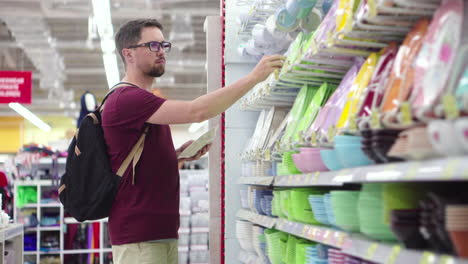 hombre comprando platos en un supermercado