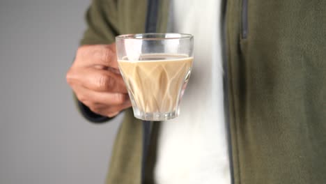 person holding a glass cup of tea or coffee